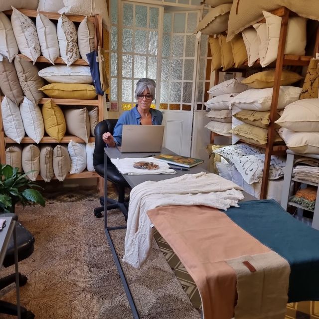 Gladys en el taller rodeada de almohadones y telas